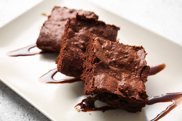 Placa con trozos de sabroso brownie de chocolate en la mesa, primer plano - Foto, imagen