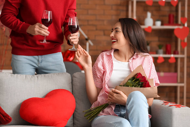 Happy young couple drinking wine at home on Valentine's Day - Fotoğraf, Görsel