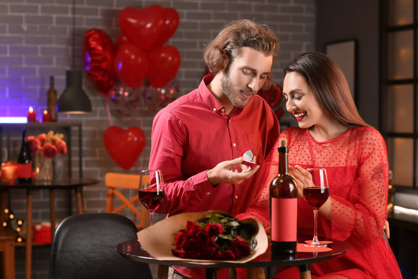 Man aanzoek aan zijn vriendin in cafe op Valentijnsdag - Foto, afbeelding