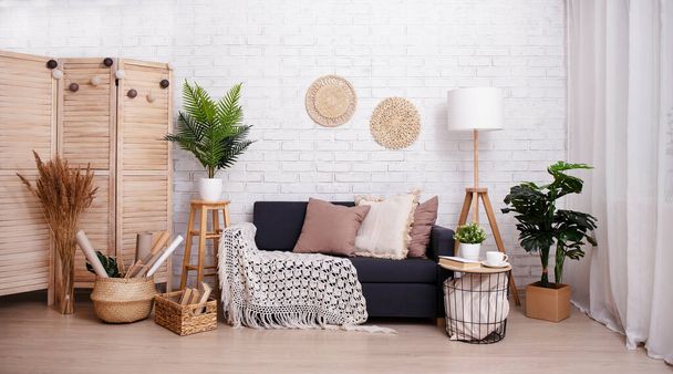 Room with sofa, lamp and plants over brick wall background - Foto, imagen