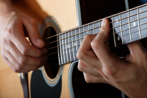 Man performing song on acoustic guitar - Fotó, kép