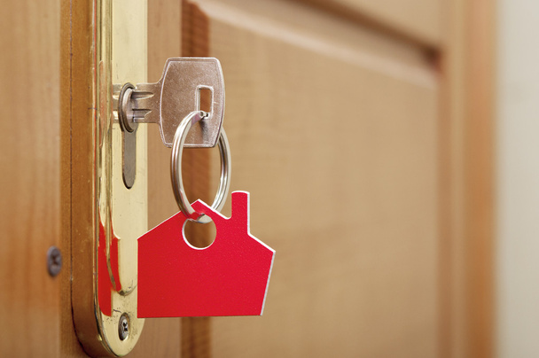Una llave en una cerradura con icono de la casa en ella  - Foto, imagen