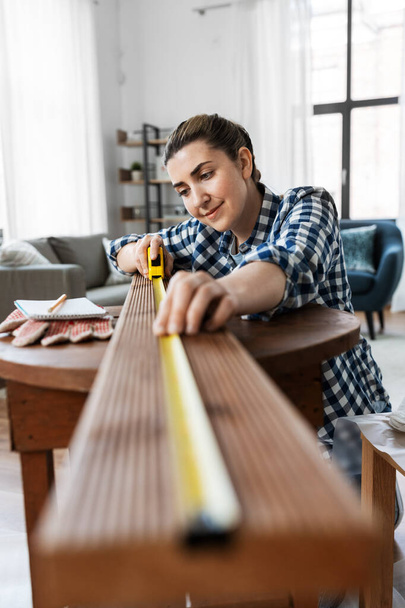 woman with ruler measuring wooden board - Foto, Imagem