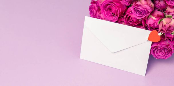 Envelope and roses on color background. Celebration concept. Space for text - Foto, Bild