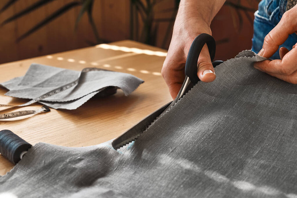 Mujer cortando un papel patrón en tela de lino. Costurera cosiendo en la máquina de coser en un pequeño estudio. Moda atelier, sastrería, concepto de ropa hecha a mano. Moda lenta Consumo consciente - Foto, imagen
