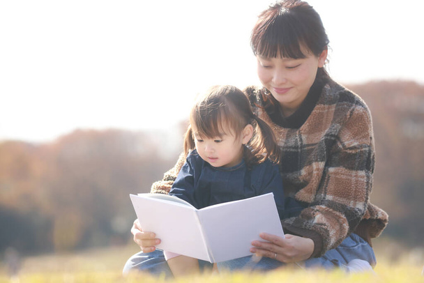 Родители и дети читают книги с картинками - Фото, изображение