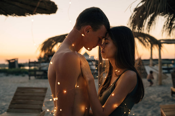 silhouette coucher de soleil de jeune couple amoureux étreignant à la plage - Photo, image