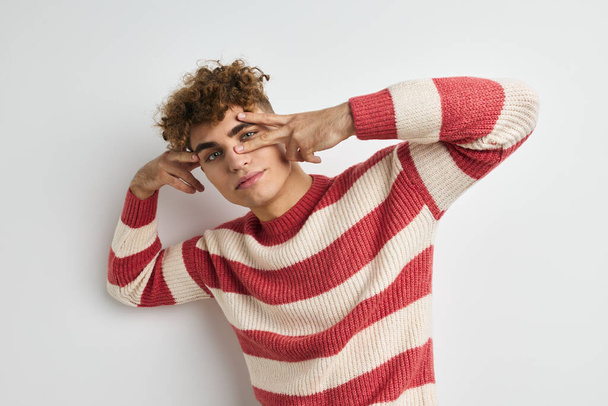 handsome young man in a striped sweater posing Lifestyle unaltered - Фото, зображення