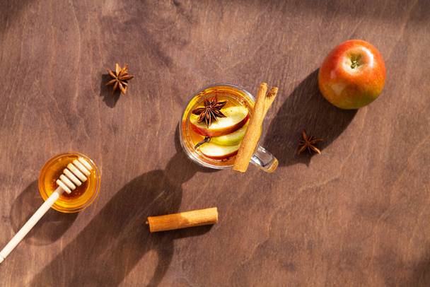zelfgemaakte appelcider en kaneel met verse appel en honing. Warme fruitthee met specerijen: kaneel, anijs op de houten tafel. Kerstdrankjes. Kopieer ruimte. bovenaanzicht - Foto, afbeelding