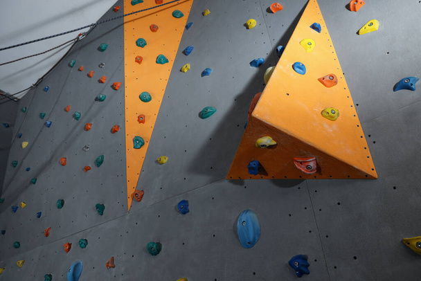Climbing wall with holds in gym. Extreme sport - Foto, Imagem