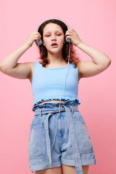 cheerful woman in denim shorts wearing headphones fashion entertainment technology unaltered - Foto, imagen