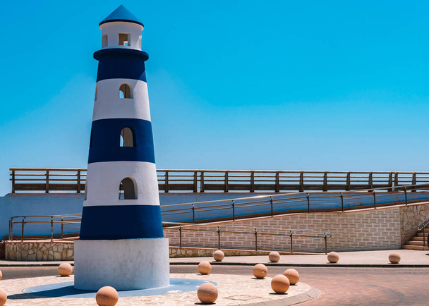 Blue lighthouse decorating the harbor - Фото, изображение