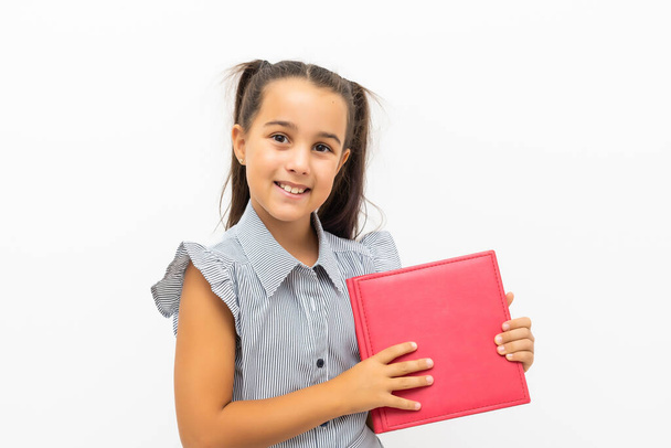 little girl isolated in white holding school book - Foto, afbeelding