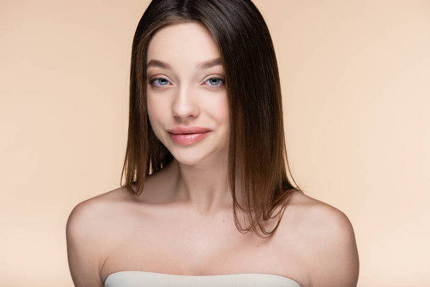 pretty young woman with bare shoulders smiling isolated on beige  - Foto, afbeelding