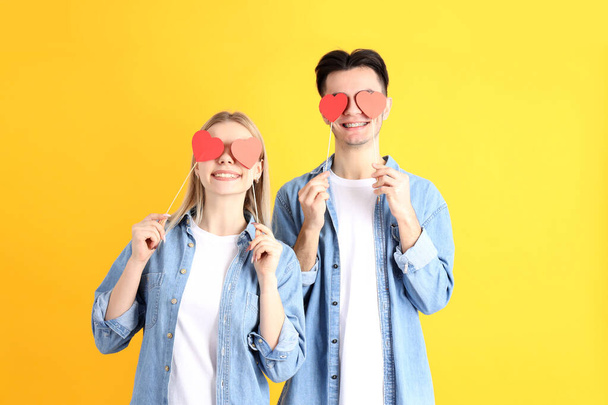 Cute couple with hearts on yellow background - 写真・画像