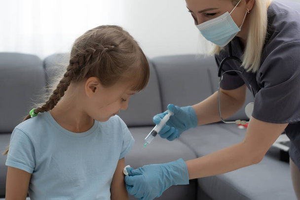 nurse giving vaccination injection to little girl patient - Photo, Image