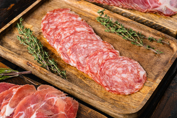 Meat antipasto, pancetta, salami, sliced ham prosciutto set, on old dark  wooden table background - Zdjęcie, obraz