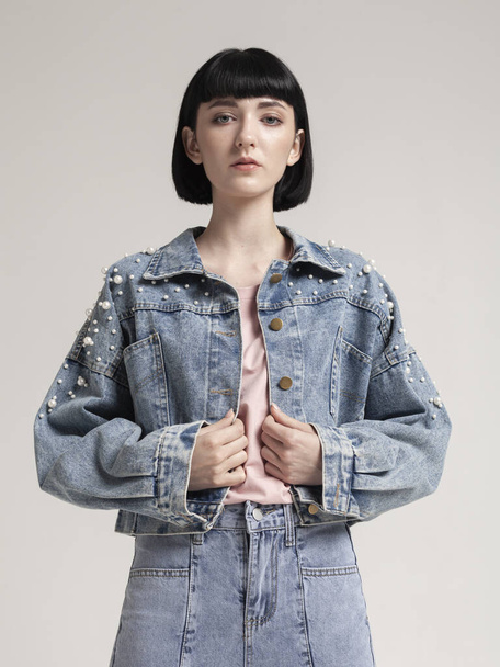 stylish girl in fashionable denim clothes on a light background - Foto, imagen