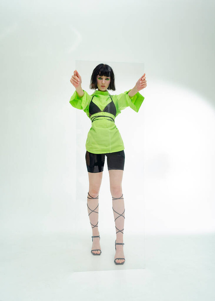 portrait of a stylish girl dressed futuristically with glass in her hands - Φωτογραφία, εικόνα