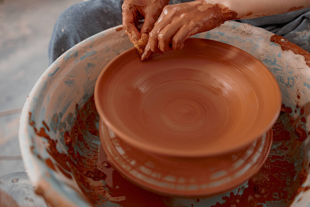 Skillful woman works on pottery wheel in ceramics workshop - Zdjęcie, obraz