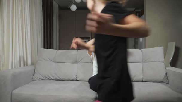 madre consigue irritado de adolescente hija corriendo alrededor sofá - Imágenes, Vídeo