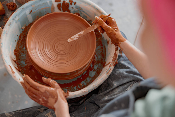 Potter trabalhando manualmente na roda de cerâmica na sala de trabalho - Foto, Imagem
