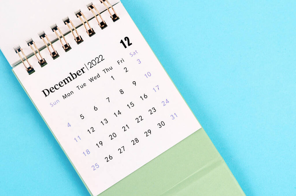 The mini December 2022 desk calendar on blue background. - Foto, Imagen