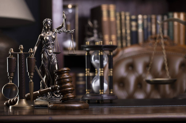Yargıç ofisi. Gavel, tartı, masadaki heykel. Kitaplıkta hukuk kitapları var.. - Fotoğraf, Görsel