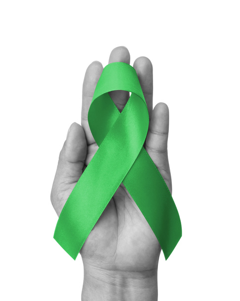 Green ribbon for gallbladder and bile duct cancer awareness month in February, bipolar disorder, mental health illness with kelly green bow isolated on white background with clipping path  - Photo, image