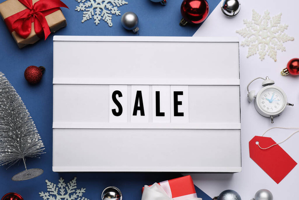 Lightbox with word Sale, gifts and Christmas decorations on color background, flat lay - 写真・画像