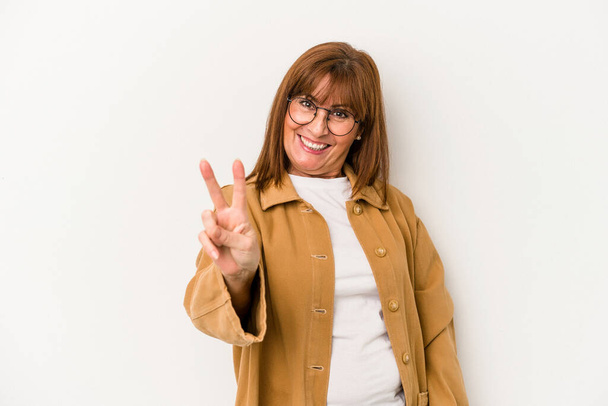 Mulher caucasiana de meia idade isolada em fundo branco alegre e despreocupada mostrando um símbolo de paz com os dedos. - Foto, Imagem
