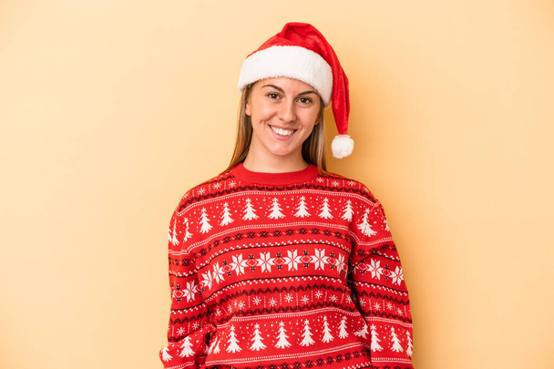 Jonge blanke vrouw vieren Kerstmis geïsoleerd op gele achtergrond gelukkig, glimlachend en vrolijk. - Foto, afbeelding