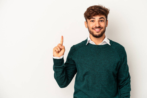 Young mixed race man isolated on grey background showing number one with finger. - Foto, Imagem
