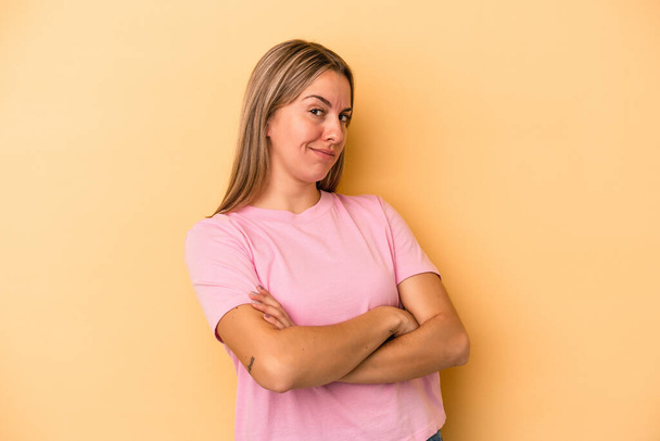 Young caucasian woman isolated on yellow background suspicious, uncertain, examining you. - Photo, Image