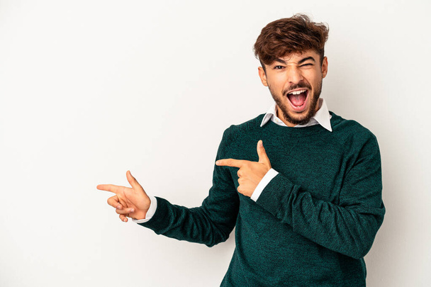 Young mixed race man isolated on grey background pointing with forefingers to a copy space, expressing excitement and desire. - Фото, изображение