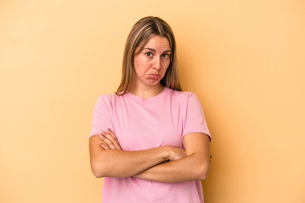 Young caucasian woman isolated on yellow background tired of a repetitive task. - Foto, Bild