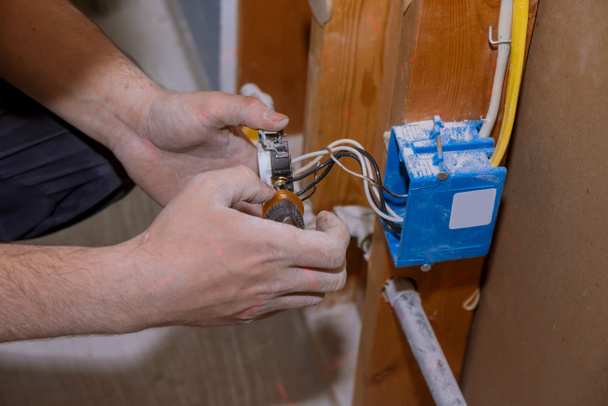Preparación para retirar una salida eléctrica de los tornillos para el panel de enchufe del receptáculo de cables eléctricos - Foto, imagen