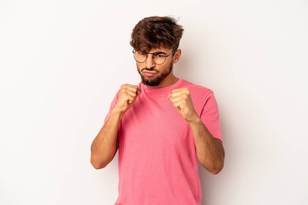 Young mixed race man isolated on grey background showing fist to camera, aggressive facial expression. - Fotó, kép