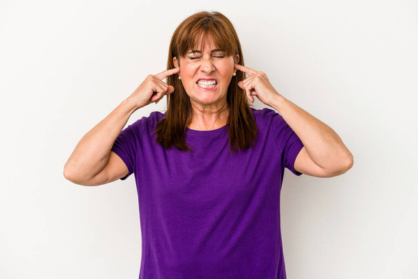 Middle age caucasian woman isolated on white background covering ears with fingers, stressed and desperate by a loudly ambient. - Valokuva, kuva