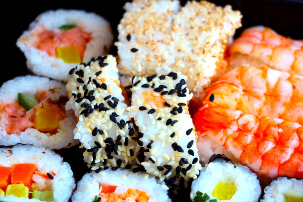 Japans sushi eten. Rollen met tonijn, zalm, garnalen. Gesorteerde sushi. Traditioneel Japans eten is sushi. - Foto, afbeelding