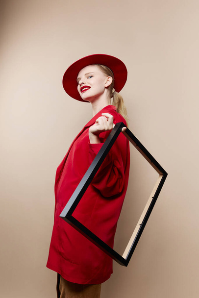 retrato de un marco de mujer en la mano en sombrero rojo y chaqueta Estilo de vida posando - Foto, Imagen