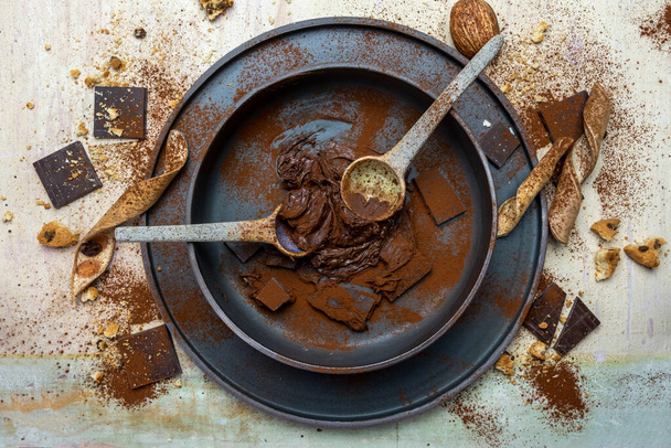 hazelnut cocoa cream and chocolate pieces mixed in a bowl on a light wood background. top view - Foto, immagini