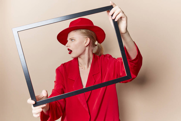 portrait of a woman with wooden frame posing red suit Lifestyle posing - Foto, Bild