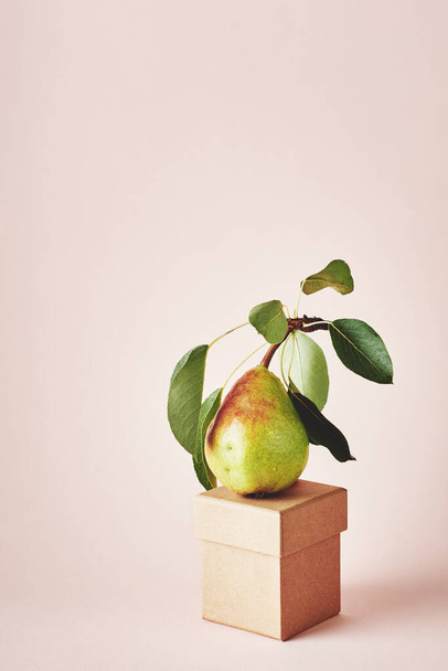 Груша з листям на рожевому тлі. концепція харчового мистецтва
. - Фото, зображення