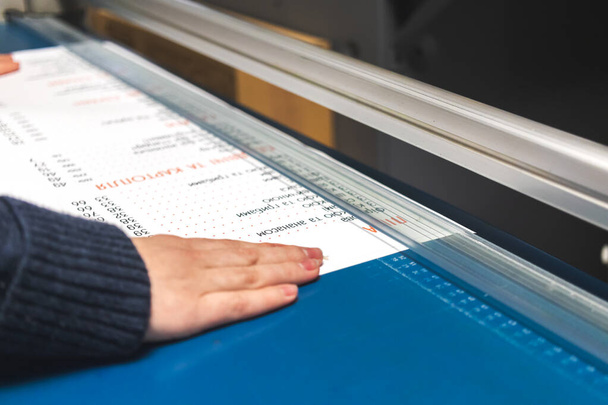 Travailleur avec machine à découper le papier dans la maison d'impression. Industrie de l'imprimerie fond - Photo, image