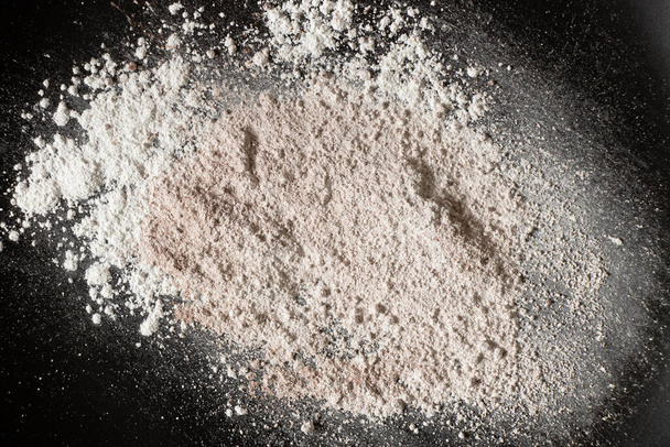 white powder on black background, flour sprinkled for background - Photo, image