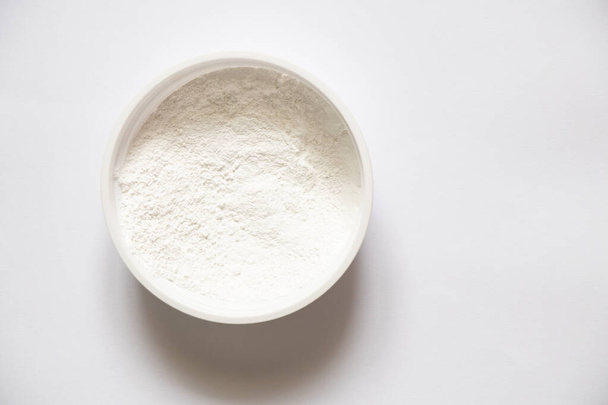 white powder in a box on a white background, tooth powder on a white background - Foto, Bild