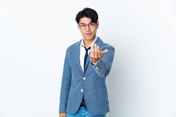Young Chinese business man isolated on white background inviting to come with hand. Happy that you came - Foto, Imagen
