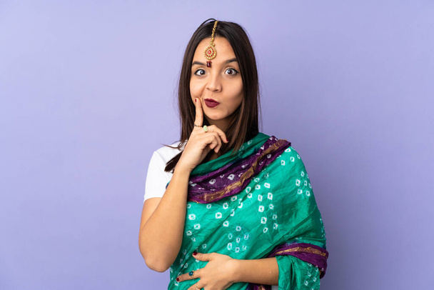Young Indian woman isolated on purple background and thinking - Foto, Imagem