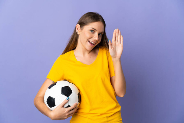 Young Lithuanian football player woman isolated on purple background saluting with hand with happy expression - Φωτογραφία, εικόνα